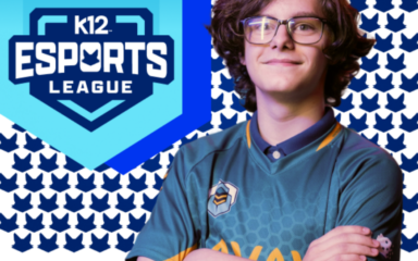 Una persona con una camiseta verde azulado de deportes electrónicos posa con los brazos cruzados delante de un fondo estampado con iconos repetidos en forma de zorro azul. A la izquierda, un gran logotipo azul en forma de escudo reza «K12 Esports League» con un emblema de zorro estilizado sobre el texto.