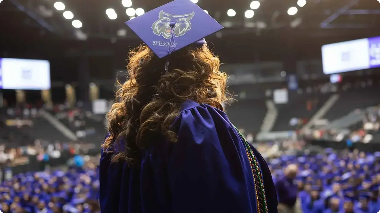 Un graduado que observa al público compuesto por otros graduados